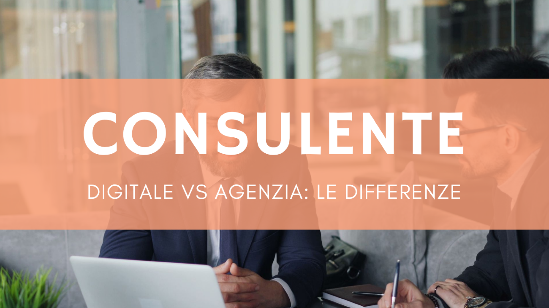 Due professionisti in riunione discutono strategia digitale per PMI al tavolo con laptop